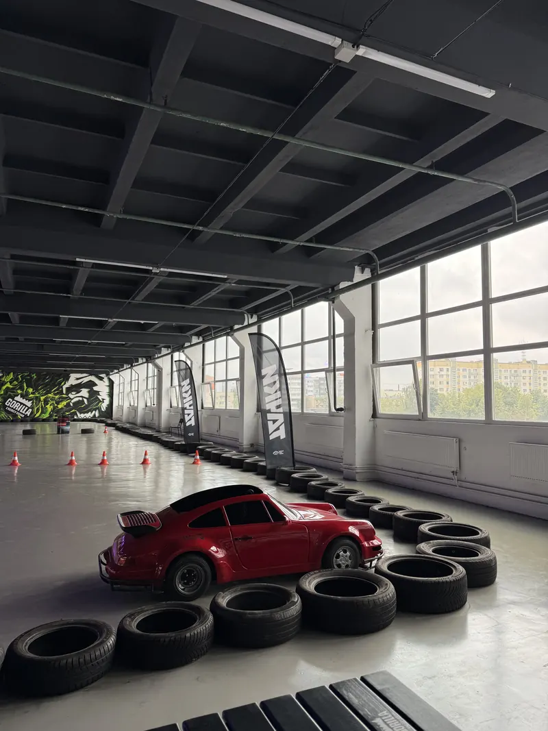 Красная мини-машина в кузове Porsche 911 в зале арены